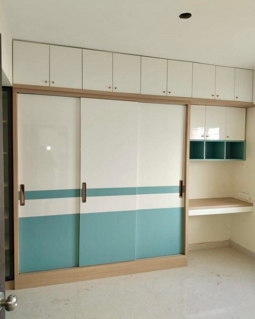 Custom sliding wardrobe with integrated study desk by Sharma Furniture